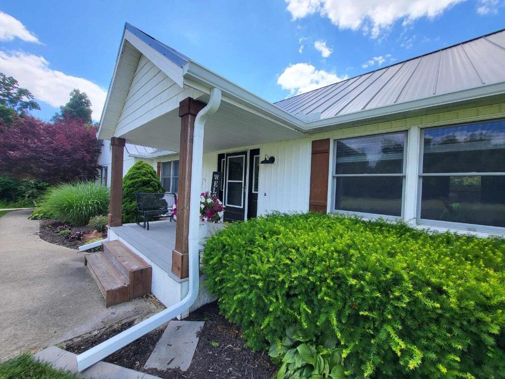White panel-sided home with metal roof and clean new seamless gutter, Greater Cincinnati